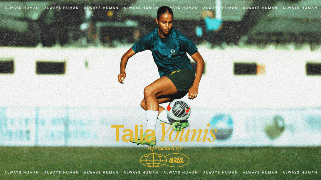Young female soccer player in teal jersey and black shorts dribbles a soccer ball on a sunny field with 'Talia Younis' overlay and Always Human branding.